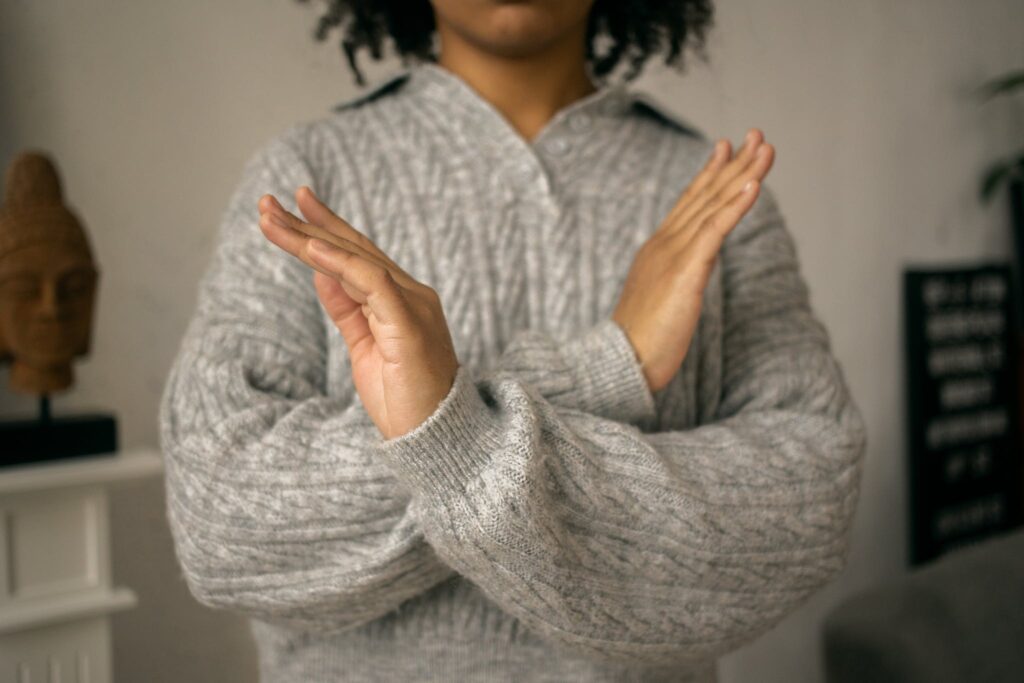 Calm black woman crossed arms as restriction sign in light room